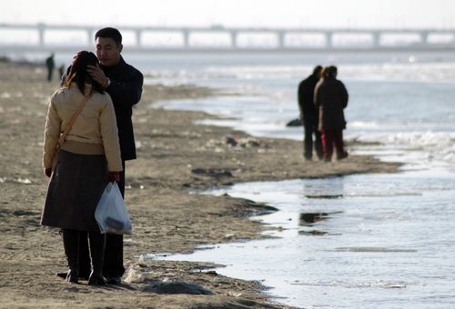 Čínský pár na břehu řeky Sung-chua. | Foto: Reuters