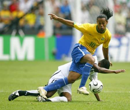 Brazilec Ronaldinho (ve žlutém) se snaží uniknout Eriku Addovi z Ghany. | Foto: Reuters