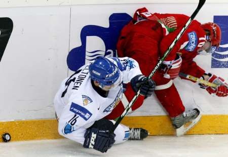 Uladzimir Denisov z Běloruska (v červeném) a finský útočník Ville Peltonen bojují u hrazení. | Foto: Reuters