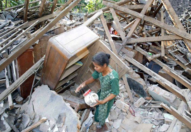 Vesničanka hledá cokoli, co přežilo zkázu jejího domku v Imogiri, na předměstí Yogyakarta. | Foto: Aktuálně.cz