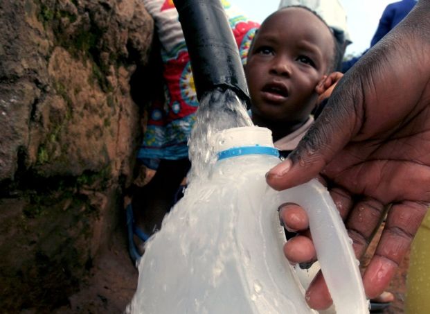 Žena v osmsetisícovém nairobském slumu Kibera jde se svým synem pro vodu. Přístup k nezávadné pitné vodě nemá přes miliardu obyvatel Zeměkoule. Pro připomenutí toho, jak je životodárná tekutina důležitá, vyhlásila OSN Mezinárodní den vody, který se slaví právě 22. března | Foto: Aktuálně.cz