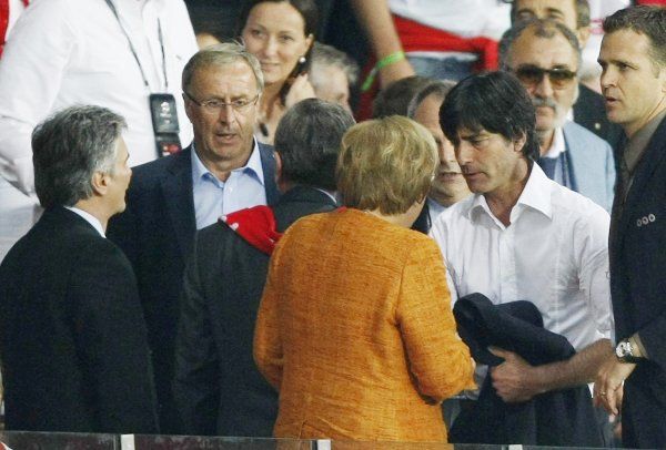 Vykázaní trenéři vysvětlovali celý incident německé a rakouské politické honoraci. Joachim Löw v debatě s německou kancléřkou Angelou Merkelovou (v oranžovém). | Foto: Reuters