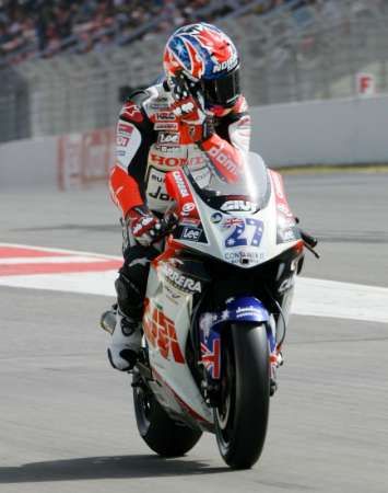 Jezdec Hondy Casey Stoner se marně snaží podrbat na hlavě při kvalifikaci na Velkou cenu Katalánska v Barceloně. | Foto: Reuters