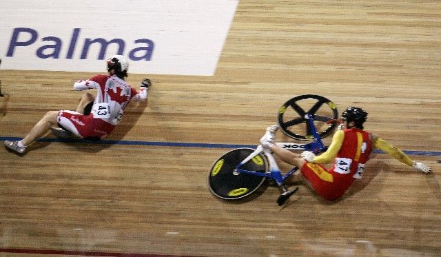 Kanaďan Travis Smith (vlevo) a Číňan Qi Tang se válí na zemi po ošklivém pádu v kvalifikaci keirinu na MS dráhových cyklistů na Mallorce. | Foto: Reuters