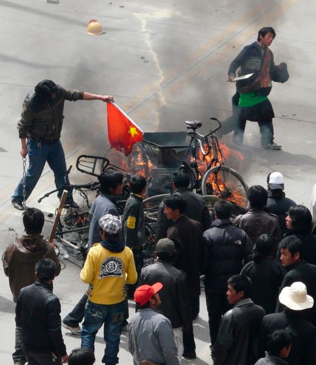 V Tibetu se rozhořely největší nepokoje za posledních dvacet let. Snímek zachycuje obyvatele hlavního města Lhasy, jak pálí čínskou vlajku. | Foto: Reuters