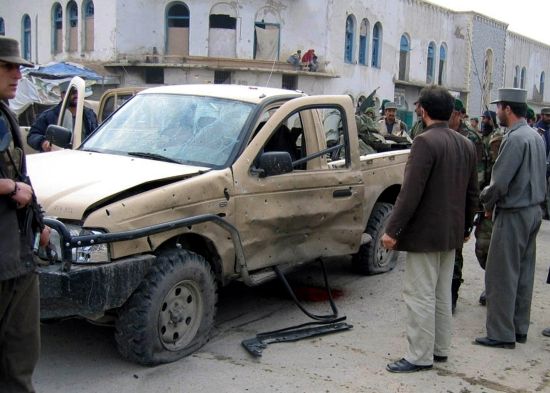 Kandahárští policisté obhlížejí auto afghánské armády, na které zaútočil sebevražedný atentátník a zabil přitom tři vojáky a dva civilisty. 16. leden 2006 | Foto: Reuters/Izmail Samím