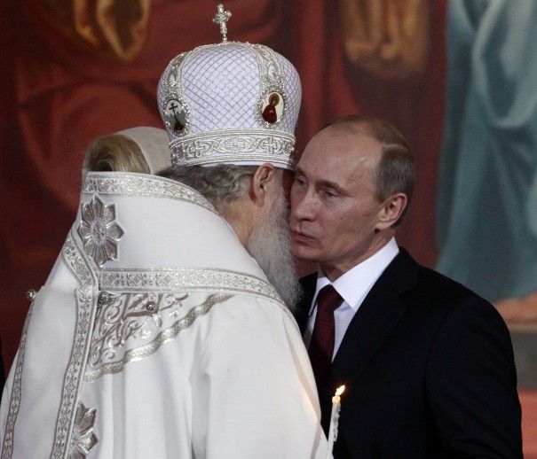 Ruský premiér Putin líbá moskevského patriarchu při bohoslužbě. | Foto: Reuters