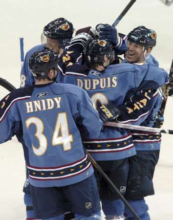 Křídlo Atlanty Thrashers Keith Tkachuk (vpravo) slaví se spoluhráči Pascalem Dupuisem (uprostřed)a Shaneem Hnidym (34) po Tkachukově gólu Bufallu. Sabres in overtime of their NHL ice hockey game at Philips Arena in Atlanta | Foto: Reuters