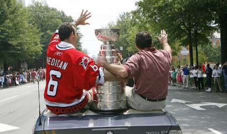 Trenér vítězů Stanley Cupu Caroliny Hurricanes, Peter Laviolette (vpravo) si užívá triumfální jízdu městem s cennou trofejí. | Foto: Reuters