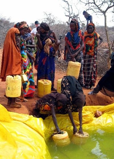 Hluboko ve wajirské buši mnoho žen a mužů čeká se starými nádobami na vodu, kterou dvakrát týdně lije cisterna do díry v zemi. | Foto: Reuters