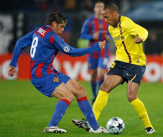 Benjamin Huggel z Basileje se snaží bránit Thierry Henryho z Barcelony | Foto: Reuters