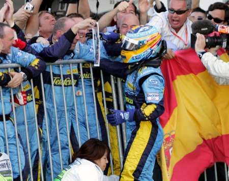 Španělský pilot F1 Fernando Alonso ze stáje Renault oslavuje se členy týmu své vítězství ve Velké ceně Japonska. | Foto: Reuters