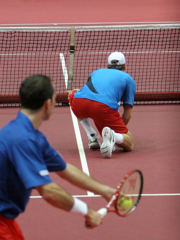 Radek Štěpánek podává přes dřepícího Tomáše Berdycha. | Foto: Ondřej Besperát