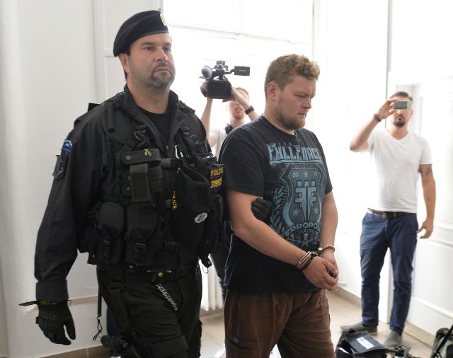 Policista přivádí  k pražskému obvodnímu soudu jednoho ze dvou cizinců, kteří posprejovali Karlův most. | Foto: ČTK