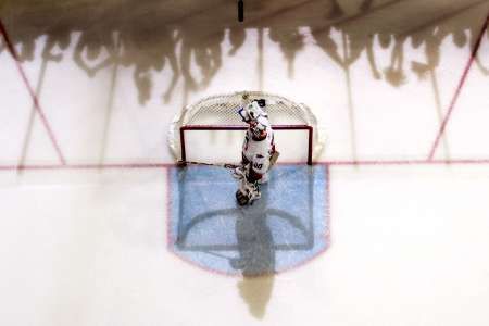 Brankář Caroliny Cam Ward po inkasovaném gólu ve finále NHL na ledě Edmontonu. Na ledě se promítají stíny nadšených fanoušků Oilers. | Foto: Andy Clark