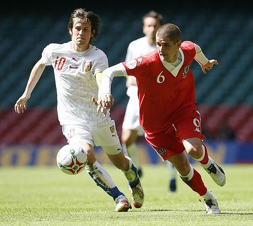 Tomáš Rosický (v bílém reprezentačním dresu) se snaží unikout Carlu Robinsonovi z Walesu. | Foto: Reuters