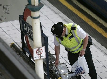 Policista prohledává odloženou tašku na londýnské stanici Aldgate. | Foto: Reuters