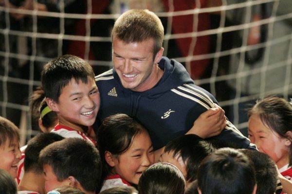 David Beckham a čínské děti na "promo" akci. Tým L.A. Galaxy dorazil do Šanghaje v neděli, ve středu sehraje utkání s druholigovým čínským celkem, v neděli ho čeká duel s Hong Kongem Union. | Foto: Reuters