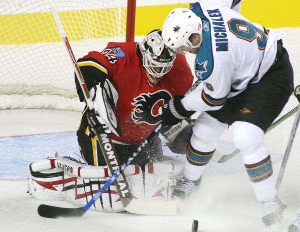 Brankář Calgary Flames Miikka Kiprusoff tentokrát kryje pokus útočníka San Jose Sharks Milana Michálka. | Foto: Reuters