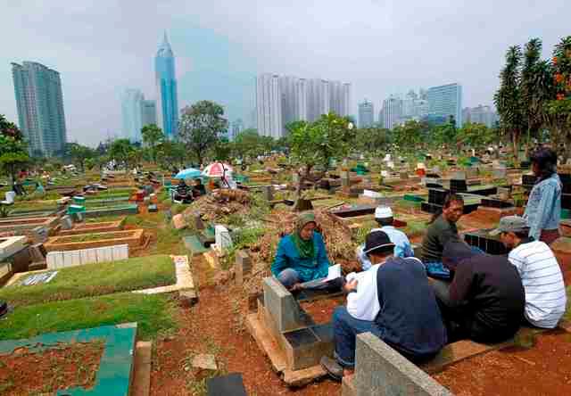 Indonéští muslimové se modlí na hrobech svých příbuzných v Jakartě. | Foto: Reuters