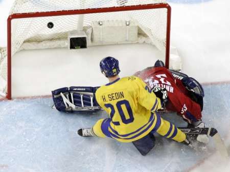 Švédský útočník Henrik Sedin (ve žlutém) dává gól do branky Milana Hniličky. | Foto: Reuters