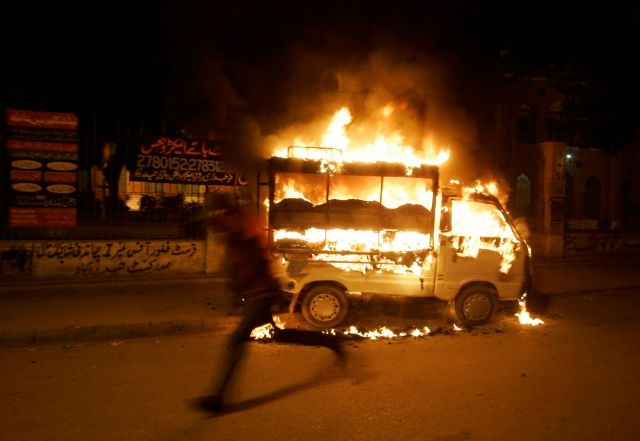 Rozvášnění příznivci Bhuttové vytáhli do ulic. Hořící vozy za nimi zůstaly i ve městě Hyderabad zhruba 160 km od Karáčí. | Foto: Reuters