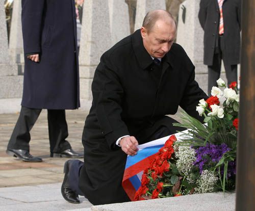 Vladimír Putin upravuje stuhu na věnci u památníku vojínů Rudé armády padlých při osvobozování Prahy | Foto: Ondřej Besperát, Aktuálně.cz