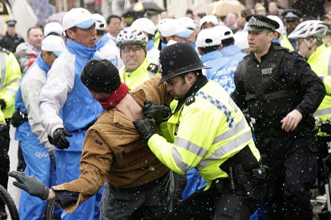 Strážník v potyčce s protestujícím poté, co se pokusil zabránit jejímu průchodu. | Foto: Reuters