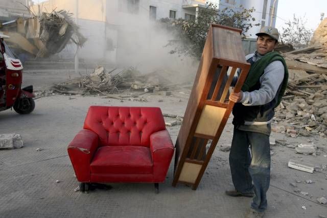 Lidé se snaží ze svých domovů zachránit, co se dá | Foto: Reuters