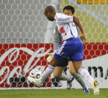 Francouzský útočník Thierry Henry (v bílém) skóruje do sítě Korejce Lee Woon-jaeho. | Foto: Reuters