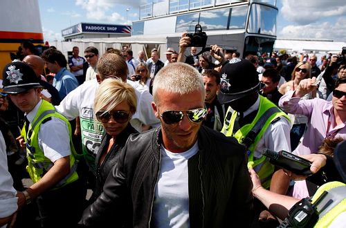 Victoria a David Beckhamovi obleženi davem fanoušků v Silverstone při btrské grand prix F1. | Foto: Reuters