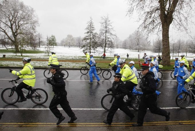 Triatletka Kirsty McWilliam veze pochodeň na kole skrz londýnský Hyde Park. | Foto: Reuters