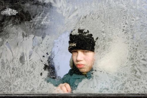 Běloruský chlapec za zamrzlým oknem autobusu v Minsku | Foto: Reuters/V.Fedorenko