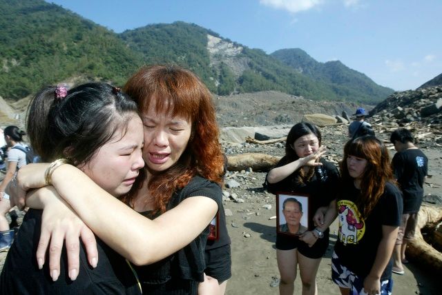 Jejich blízcí se nacházejí někdy pod nimi. Příbuzní obětí pláčou v zavalené vesnici Šao Lin. | Foto: Reuters