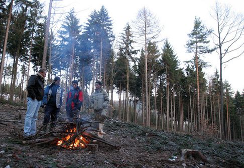 At 7 am in the Krušné hory (Ore Mountains) it is extremely cold. The first thing Kubas's employees do is make a fire to get warm. Only then they start struggling with the frozen branches covered with snow. | Foto: Ondřej Besperát