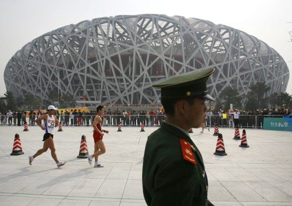 Vůbec prvním závodem, který se v Ptačí hnízdě konal, byl nedělní "Good Luck Beijing Race Walking Challenge". soutěž chodců. Na atlety dohlíží policista. | Foto: Reuters