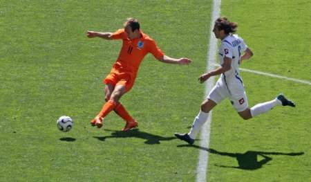 Nizozemský útočník Arjen Robben (v bílém) střílí první gól svého týmu proti Srbsku a Černé Hoře, dobíhá Goran Gavrancic. | Foto: Reuters