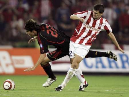 Kaká z AC Milán (vlevo) padá v souboji s hráčem Crvena Zvezdy Bělehrad Dejanem Milovanovičem. | Foto: Reuters