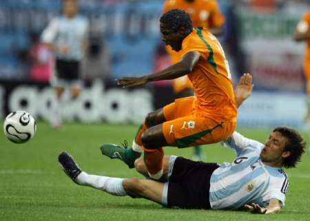 Argentinec Gabriel Heinze (dole) fauluje Abdelkadera Keitu z Pobřeží Slonoviny. | Foto: Reuters