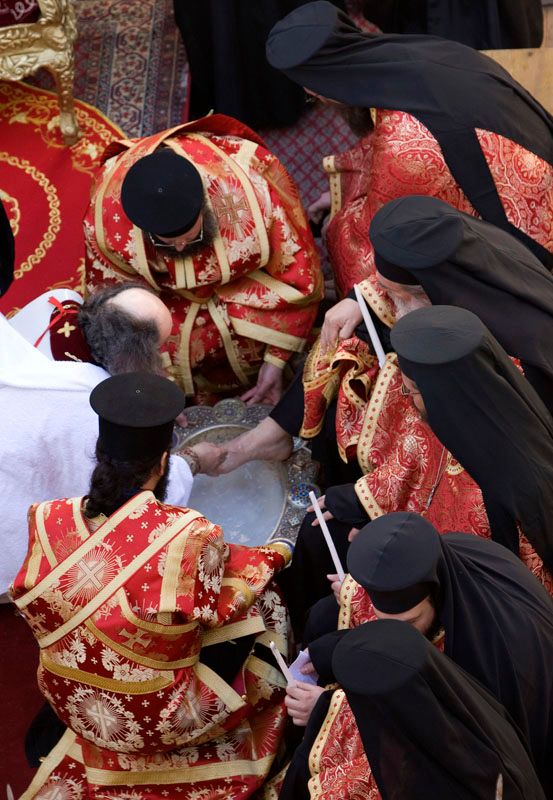 Jeruzalémský patriarcha Theofilos myje nohy kněžím při tradičním rituálu. | Foto: Reuters