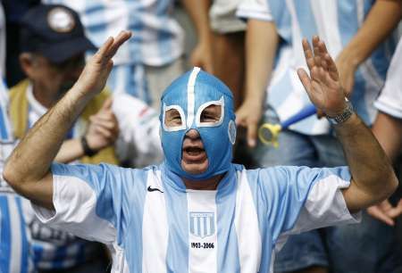 Argentinský fanoušek s maskou v národních barvách v hledišti před zápasem s Německem. | Foto: Reuters