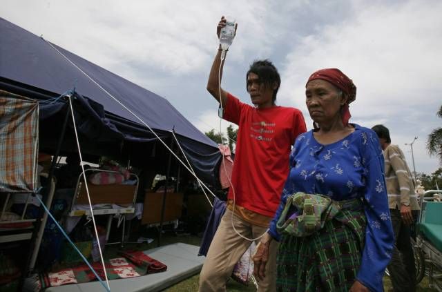 Záběr z provizorní polní nemocnice v Bengkulu: Chlapec nese matčinu infuzi. | Foto: Reuters