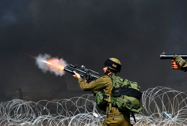 Izraelští vojáci střílejí slzný plyn na palestinské demonstranty u checkpointu Kalandíja nedaleko Ramalláhu. | Foto: Reuters