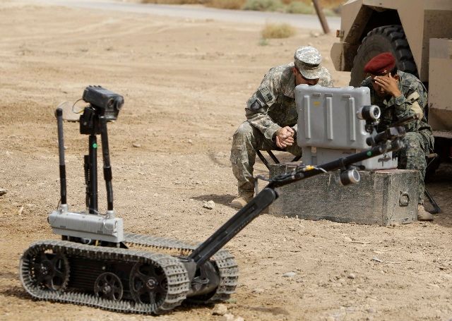 Američtí vojáci učí své kolegy, jak zacházet s robotem pro manipulaci s podezřelými předměty. Bagdád 8. října. | Foto: Reuters