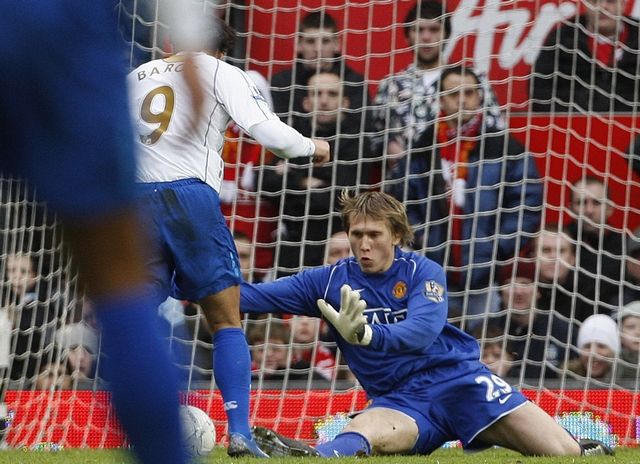 Brankář Manchesteru United Thomas Kuszczak fauluje pronikajícího Milana Baroše z Portsmouthu ve čtvrtfinále FA Cupu. | Foto: Reuters