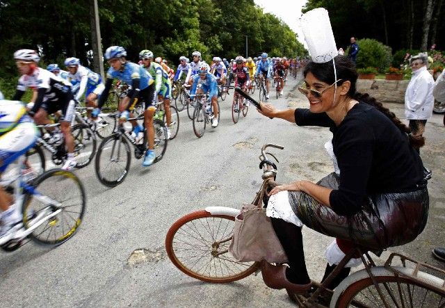 Vymóděná fanynka i s nejnovějším modelem velocipédu fandí projíždějícímu pelotonu Tour. | Foto: Reuters