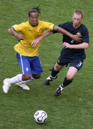 Brazilec Ronaldinho (vlevo) v soubojui s Craigem Moorem z Austrálie. | Foto: Reuters