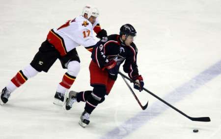 David Výborný ujíždí útočníkovi Calgary Chrisi Simonovi. | Foto: Reuters