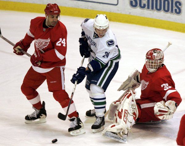 Dva veteráni: Dominik Hašek a Chris Chelios brání střeleckému pokusu Matta Cookea. | Foto: Reuters