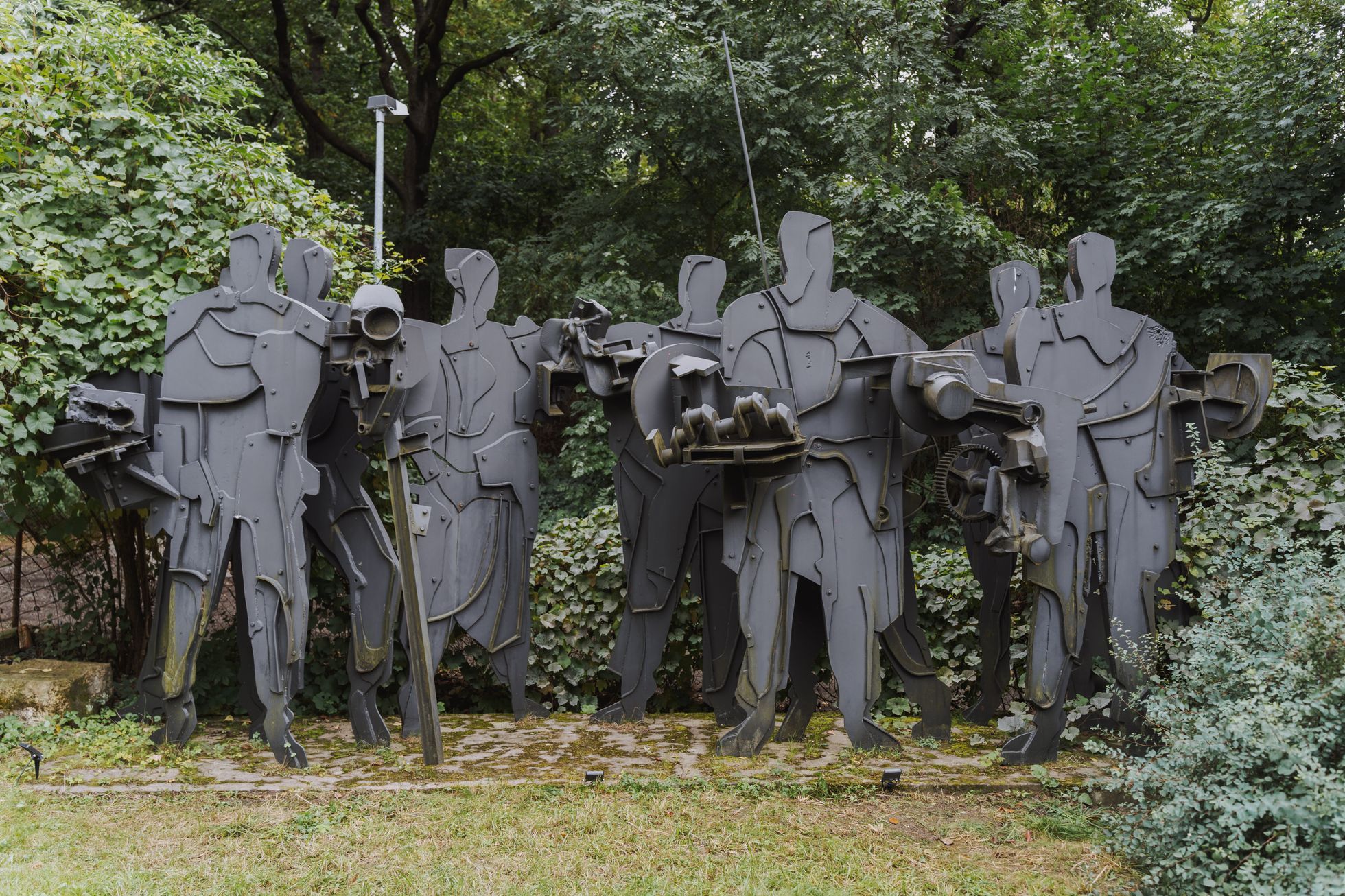 Ten men of steel are waiting in the garden.  He opened a studio of important sculptors